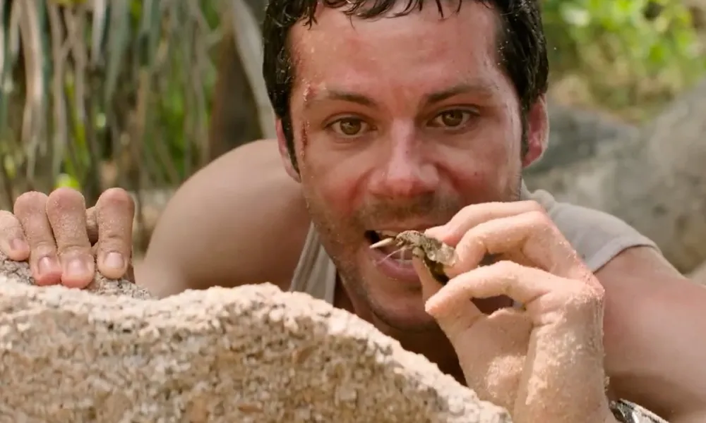 Bradley about to eat a bug after he started to starve in Send Help.